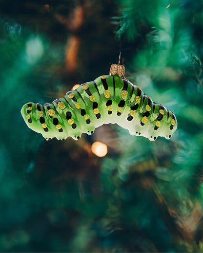 Fin lille grøn larve julekugle i glas hængende i juletræet