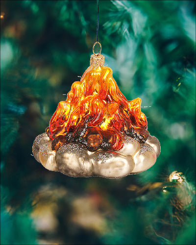 Stemningsfuld julekugle i glas, der forestiller et lejrbål