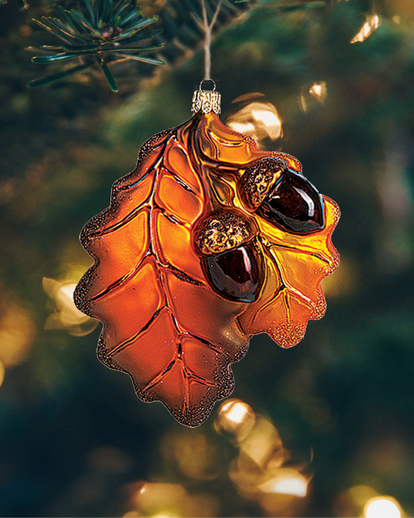 Smukke egeblade og agern julekugle i glas hængende i juletræet