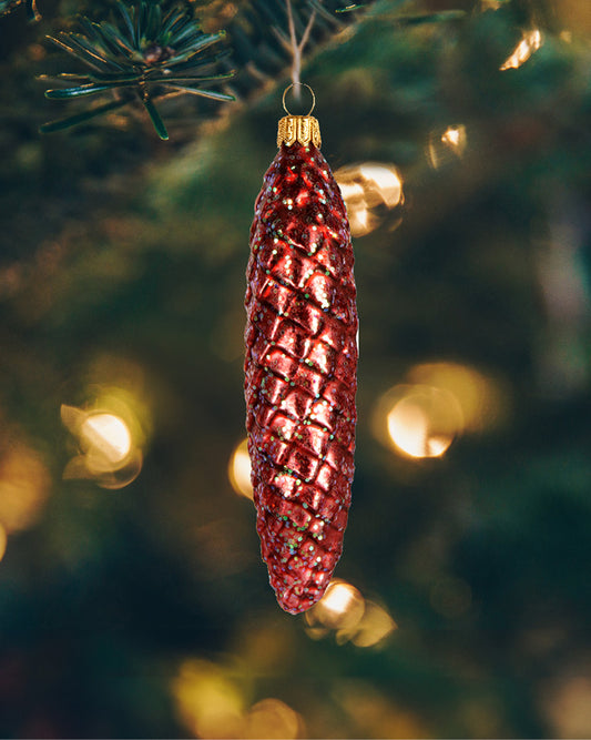 Fin lille kogle julekugle i glas hængende i juletræet