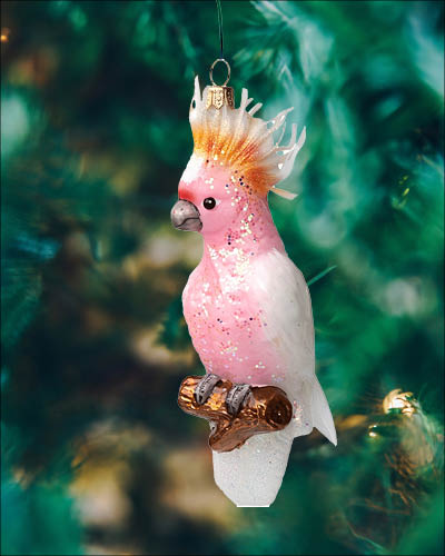 Håndmaler og mundblæst glasjulekugle, der forestiller en lyserød kakadue