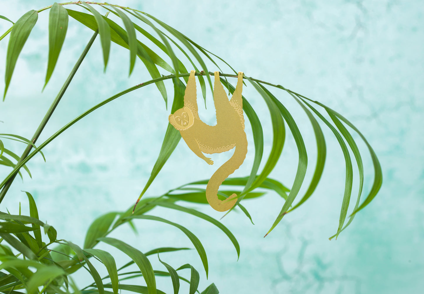 Flot lemur i messing hængende fra en plante